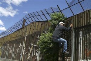 Foto de archivo de una persona intentando trepar el muro fronterizo entre la localidad mexicana de Nogales y Arizona en Estados Unidos, mayo 1 2010. El plan de Estados Unidos para construir un muro en su frontera sur causó protestas en México y dividió a los estadounidenses cuando fue aprobado en una ley en el 2006, pero el tema quedó ensombrecido a raíz de la recesión económica del año pasado.  REUTERS/Alonso Castillo